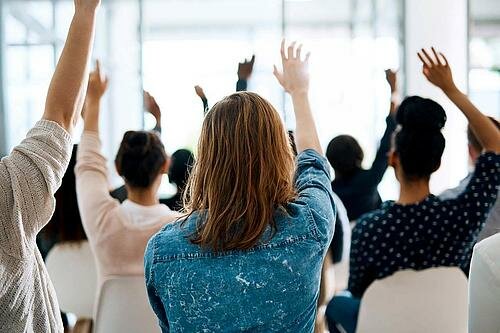 Person steht auf großem Block neben Person, die auf kleinem Block steht